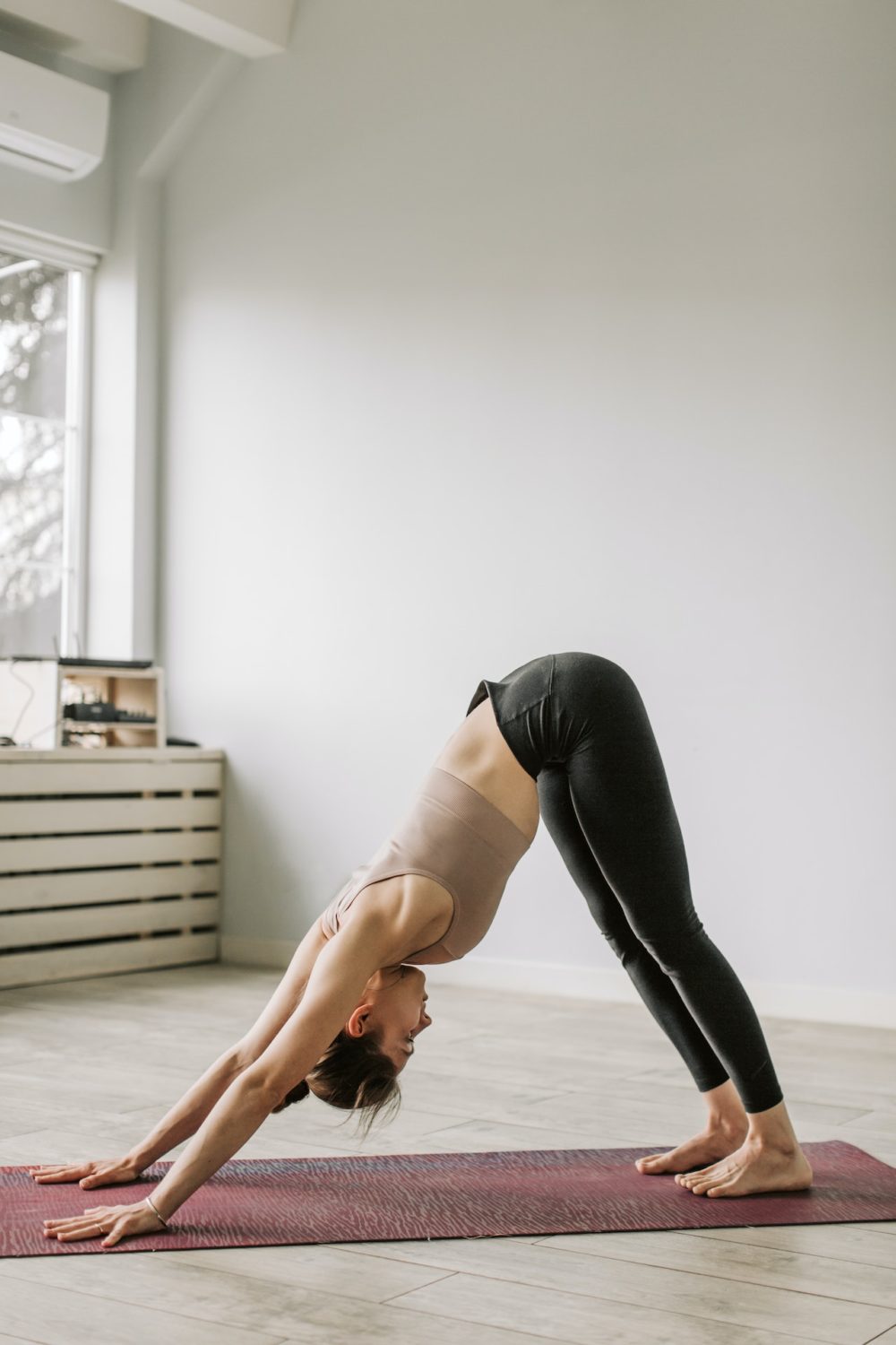 Mujer practicando yoga suave en casa, con luz natural, transmitiendo calma y equilibrio emocional